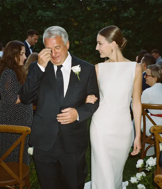 Father wiping a tear as he walks the bride down the aisle