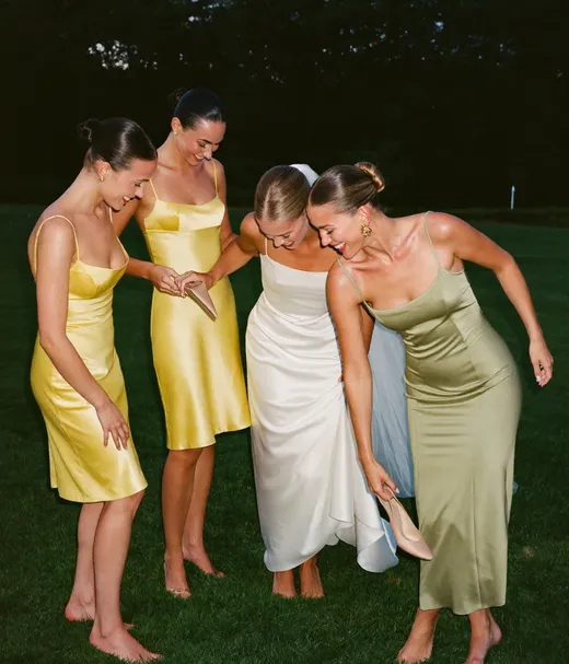 Bride and bridesmaids barefoot on the lawn