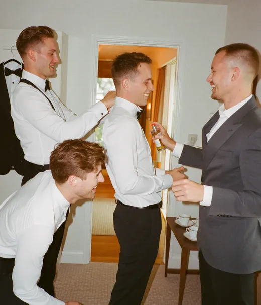 Groomsmen fixing the groom's bow tie before the ceremony