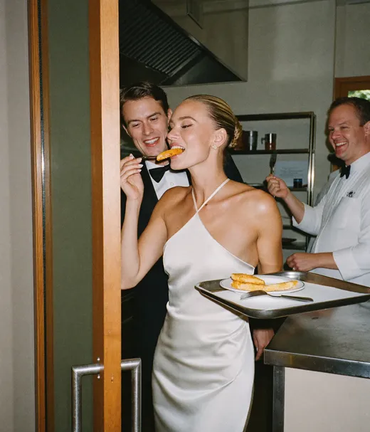 Wedding guests sharing a late-night kitchen bite