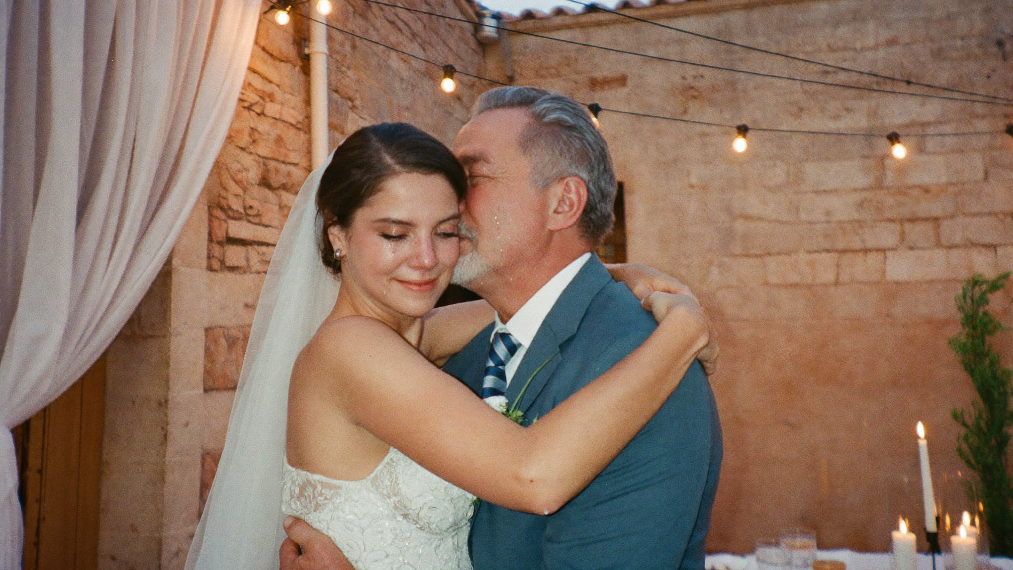 A candid bride and father embrace at a Tuscan wedding