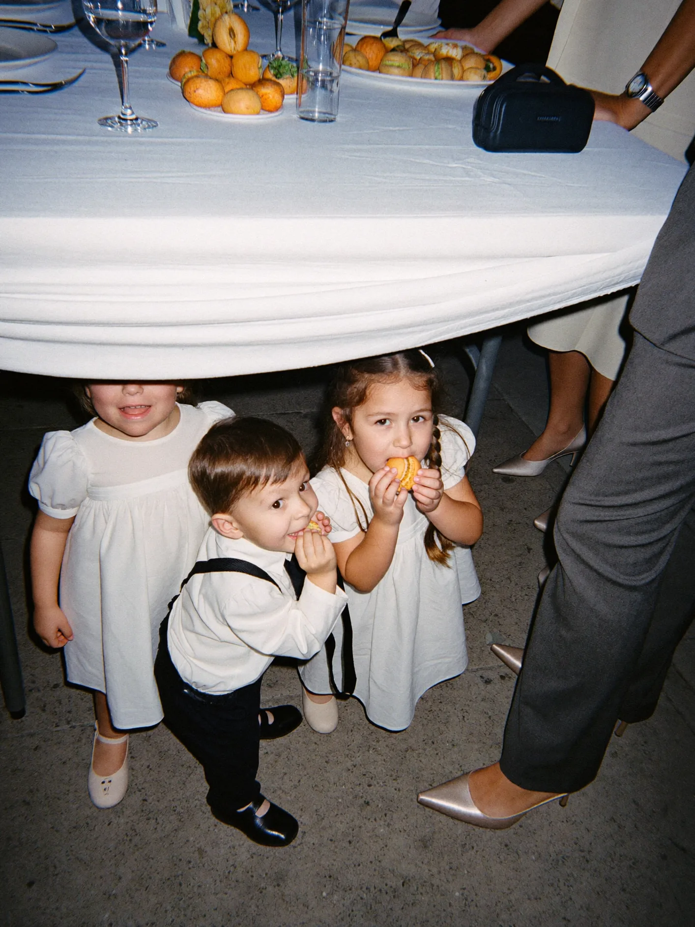 Children playing under a wedding reception table