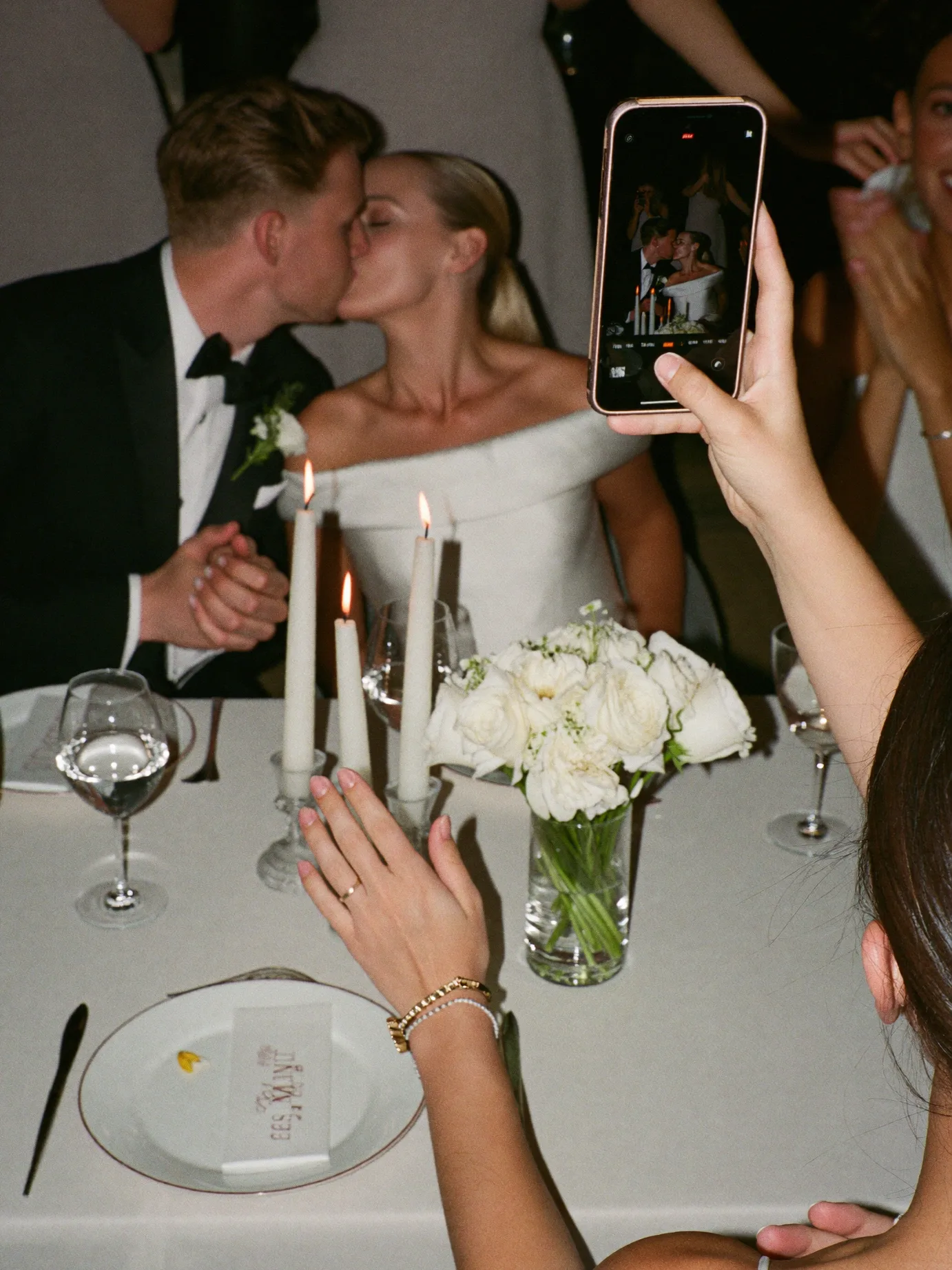 A guest filming the couple kissing on a phone